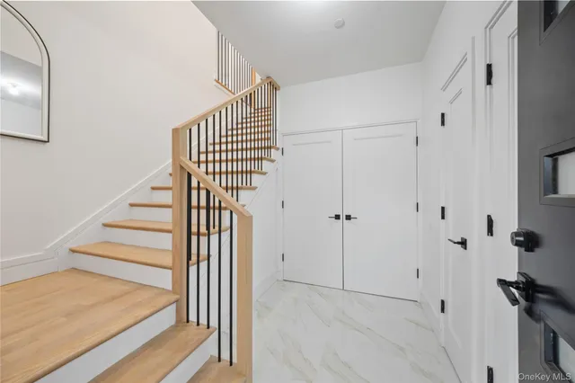 a view of hallway with stairs and wooden floor
