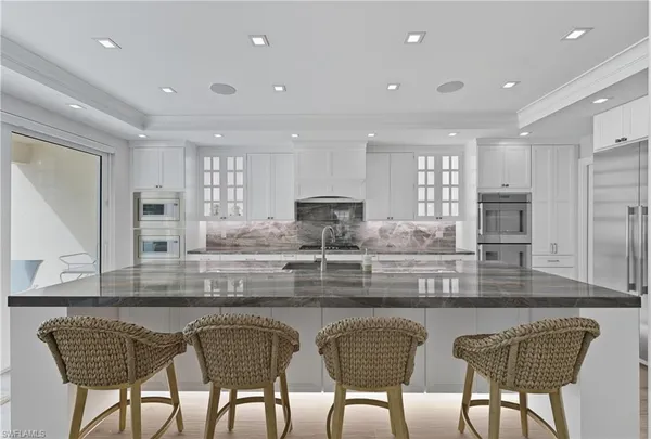 a kitchen with stainless steel appliances granite countertop a table and chairs
