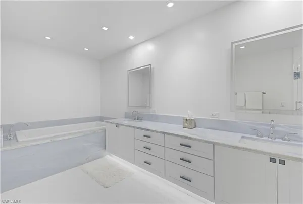 a bathroom with a granite countertop sink mirror and cabinets