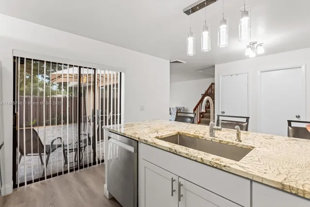a kitchen with a sink and a large mirror with wooden floor