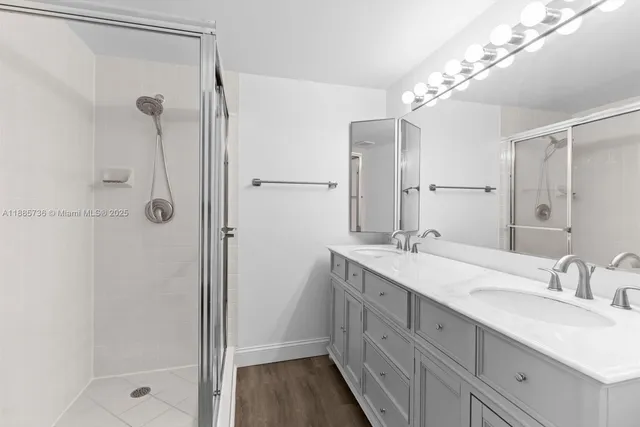 a bathroom with a double vanity sink mirror and shower
