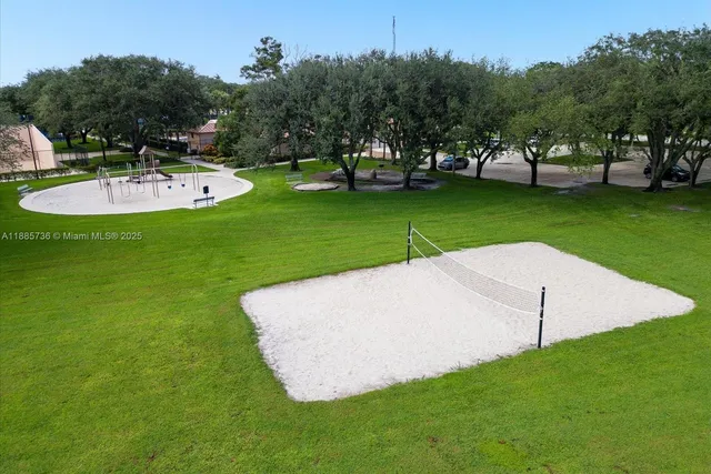 an aerial view of residential houses with outdoor space and trees
