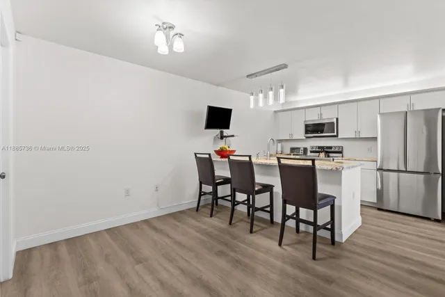a kitchen with a dining table chairs appliances and cabinets