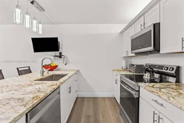 a kitchen with a sink stove and microwave
