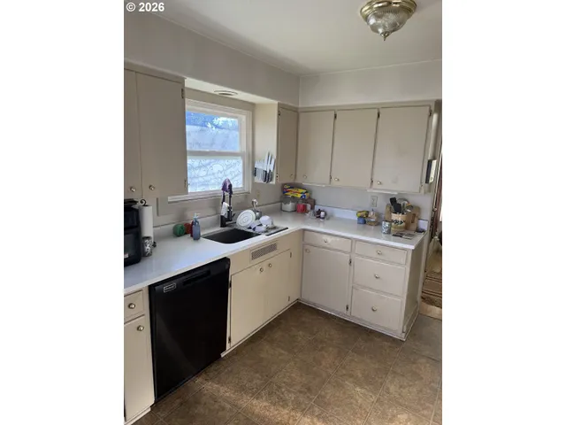 a kitchen with a sink cabinets and window