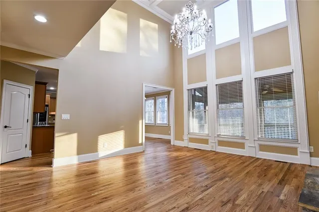 a large kitchen with stainless steel appliances granite countertop a stove top oven a sink dishwasher a dining table and chairs with wooden floor