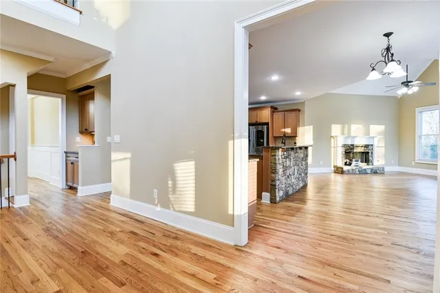 a kitchen with stainless steel appliances granite countertop a stove top oven a sink dishwasher a refrigerator and a oven with wooden floor