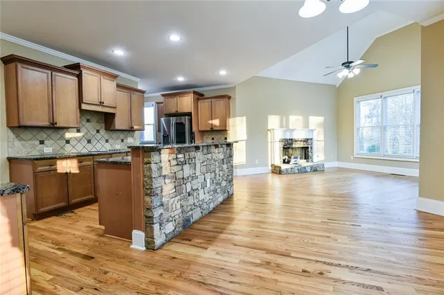a kitchen with granite countertop stainless steel appliances a refrigerator and cabinets