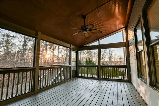 a view of a hallway to a livingroom with wooden floor and staircase