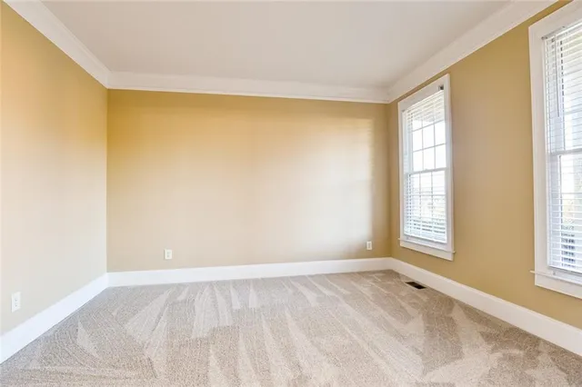 a view of a kitchen from an empty room and wooden floor