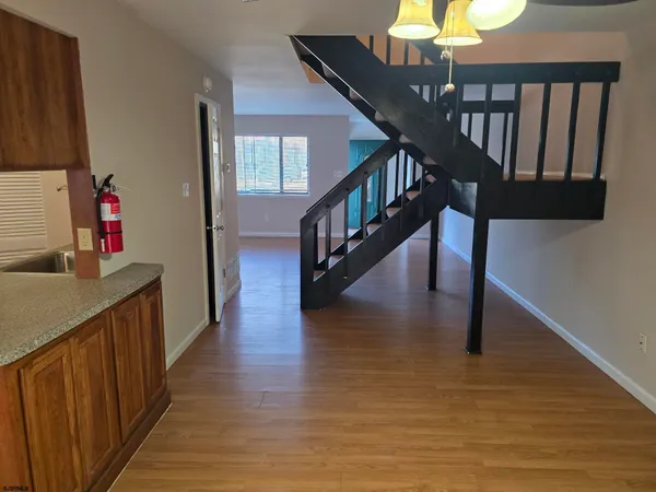a kitchen with stainless steel appliances granite countertop a sink a stove and a wooden floors
