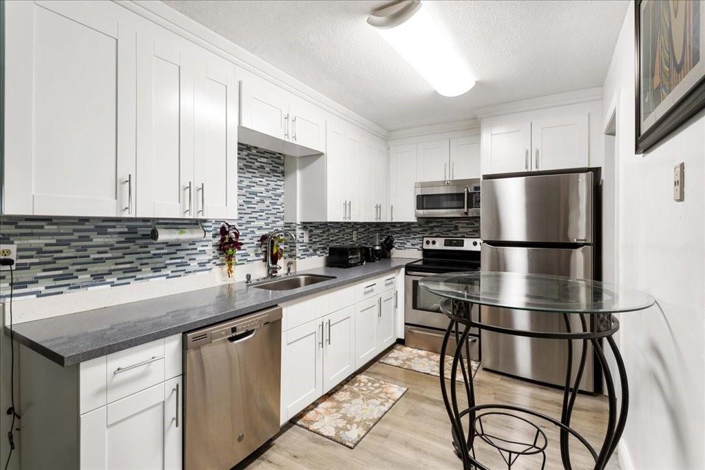 6800 Northwest 75th Drive Tamarac, FL 33321 - Photo 7 of 20 a kitchen with a refrigerator a microwave a sink and cabinets