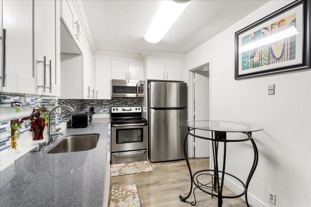 6800 Northwest 75th Drive Tamarac, FL 33321 - Photo 8 of 20 a kitchen with stainless steel appliances granite countertop a refrigerator and a stove top oven