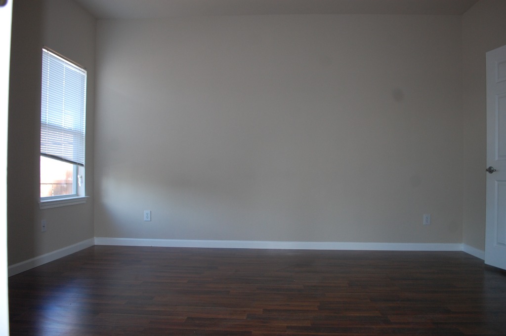 11300 Dimmit Street Manor, TX 78653 - Photo 11 of 23 A well-lit room featuring rich hardwood flooring and a single window.