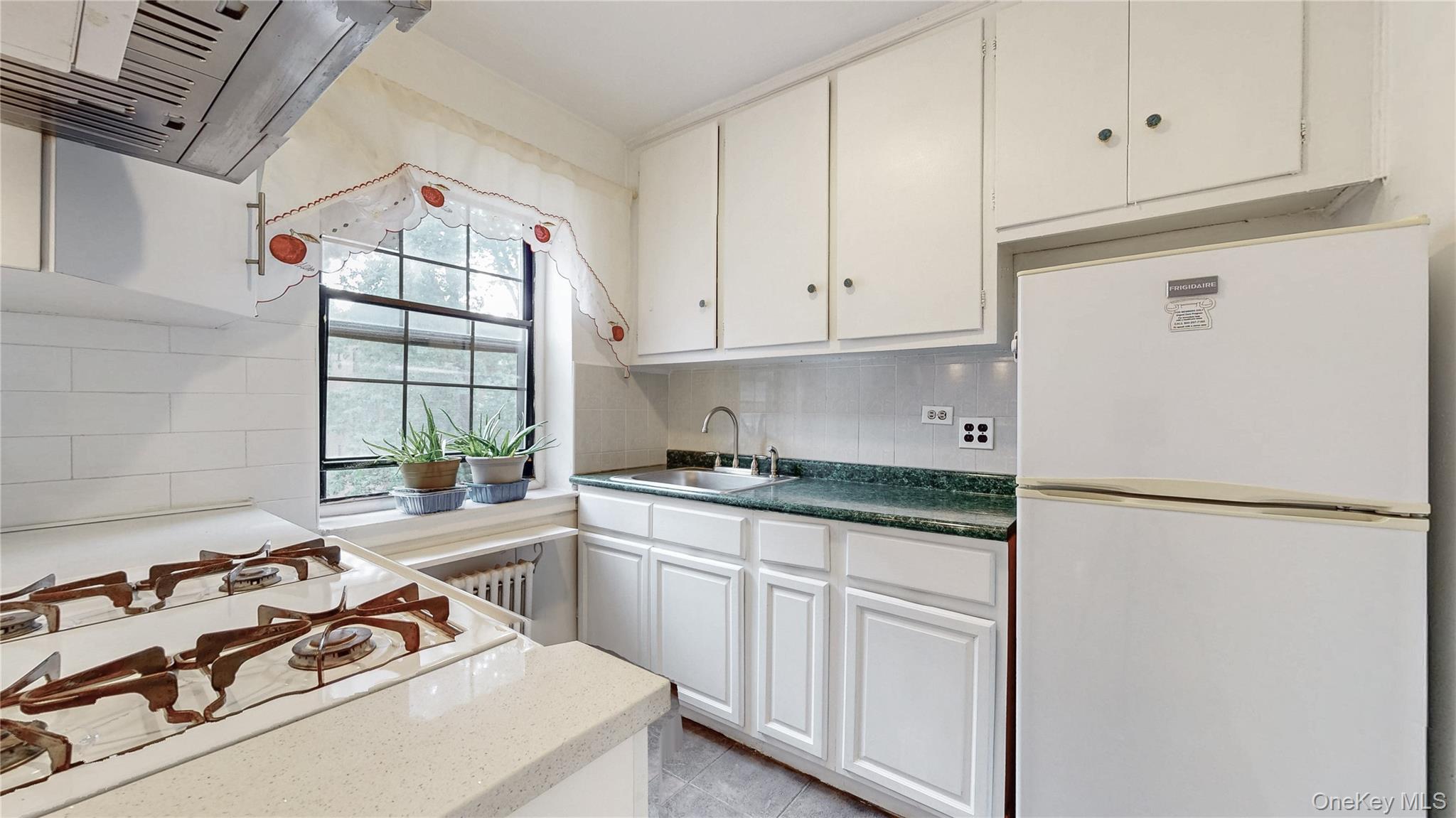 a kitchen with white cabinets and white appliances