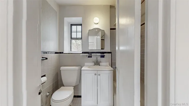 a bathroom with a toilet a sink and mirror