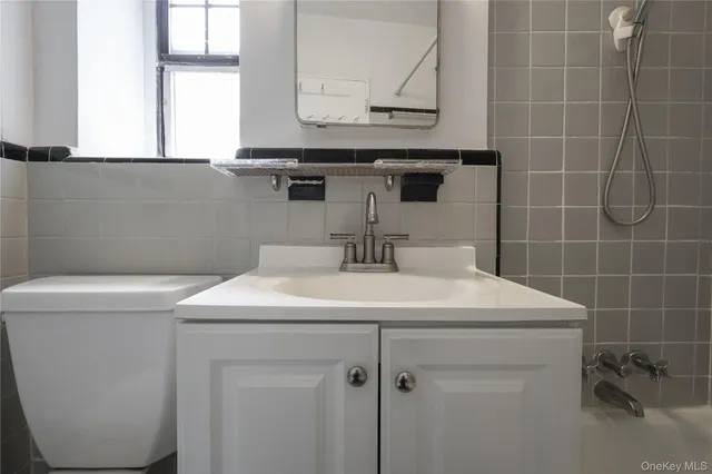 a bathroom with a sink a toilet and a mirror