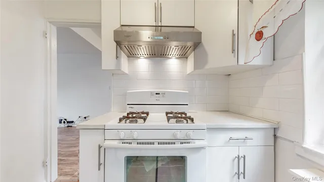 a stove top oven sitting inside of a kitchen