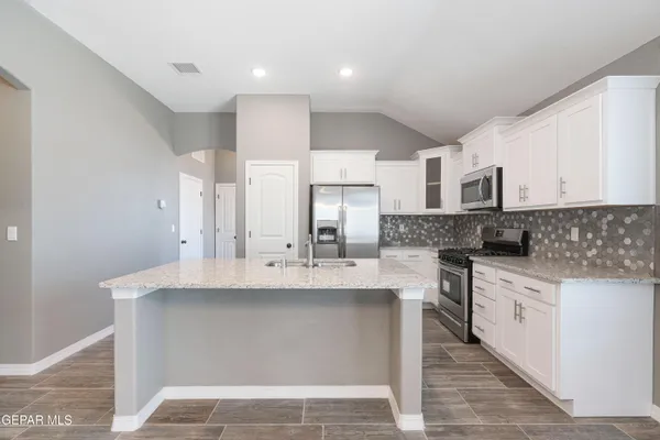 a large kitchen with kitchen island a sink stainless steel appliances and cabinets