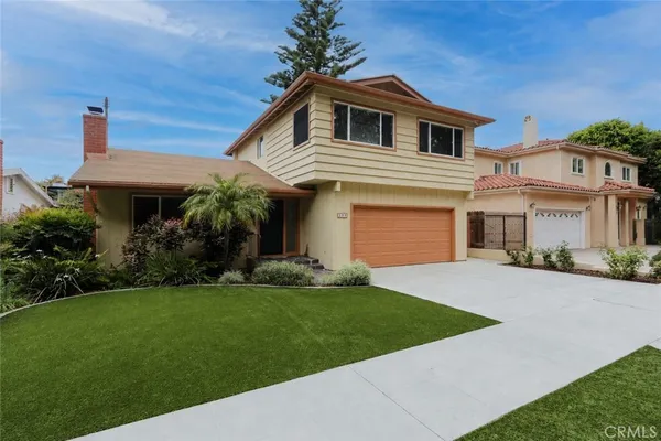 a front view of a house with a garden and yard