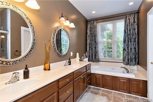 294 Chisholm Trail Rutherfordton, NC 28139 - Photo 18 of 31 a spacious bathroom with a double vanity sink a large mirror and a bathtub next to a window