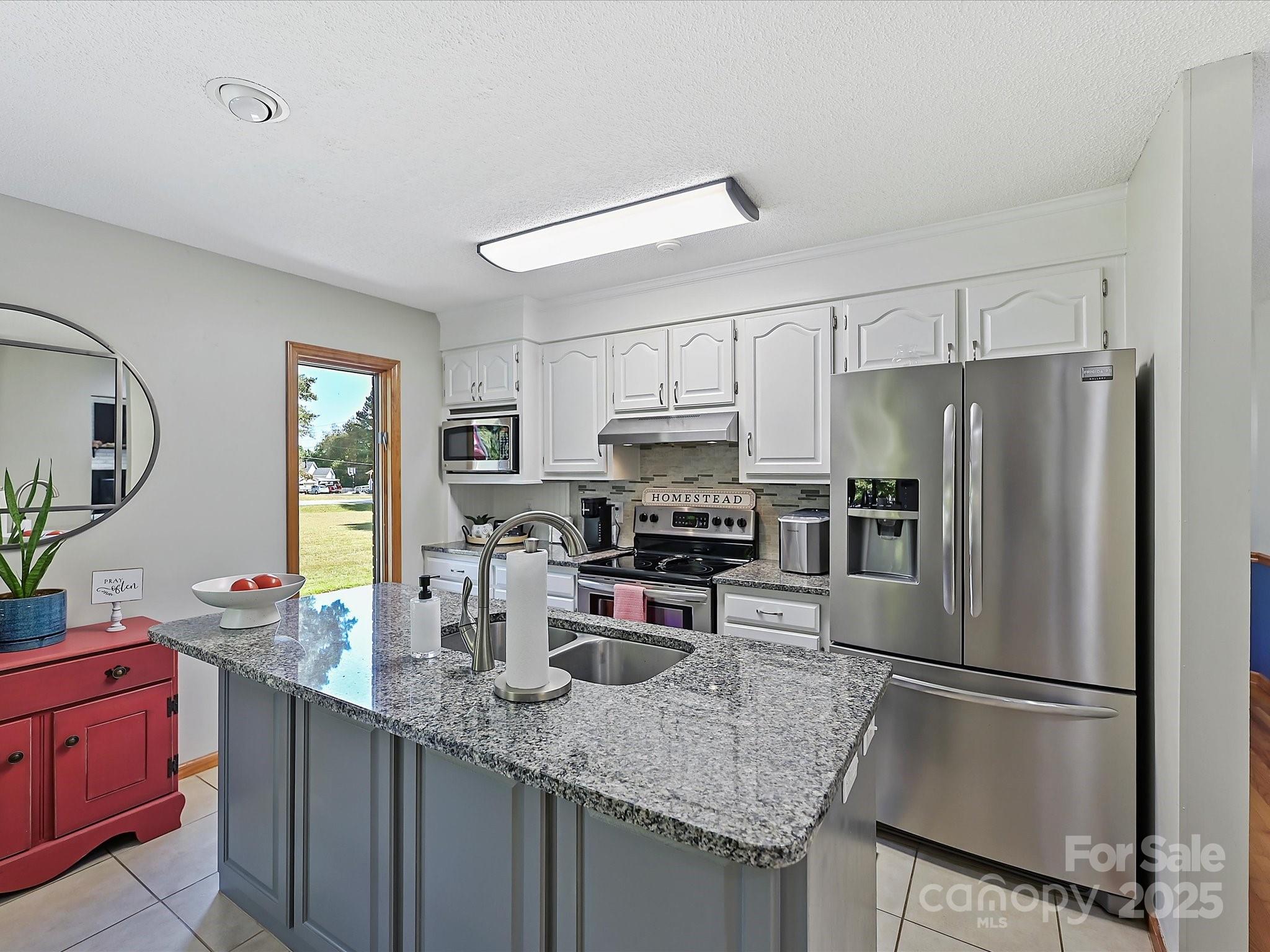 7146 Sifford Road Stanley, NC 28164 - Photo 13 of 42 a kitchen with kitchen island a counter top space cabinets stainless steel appliances and a counter space