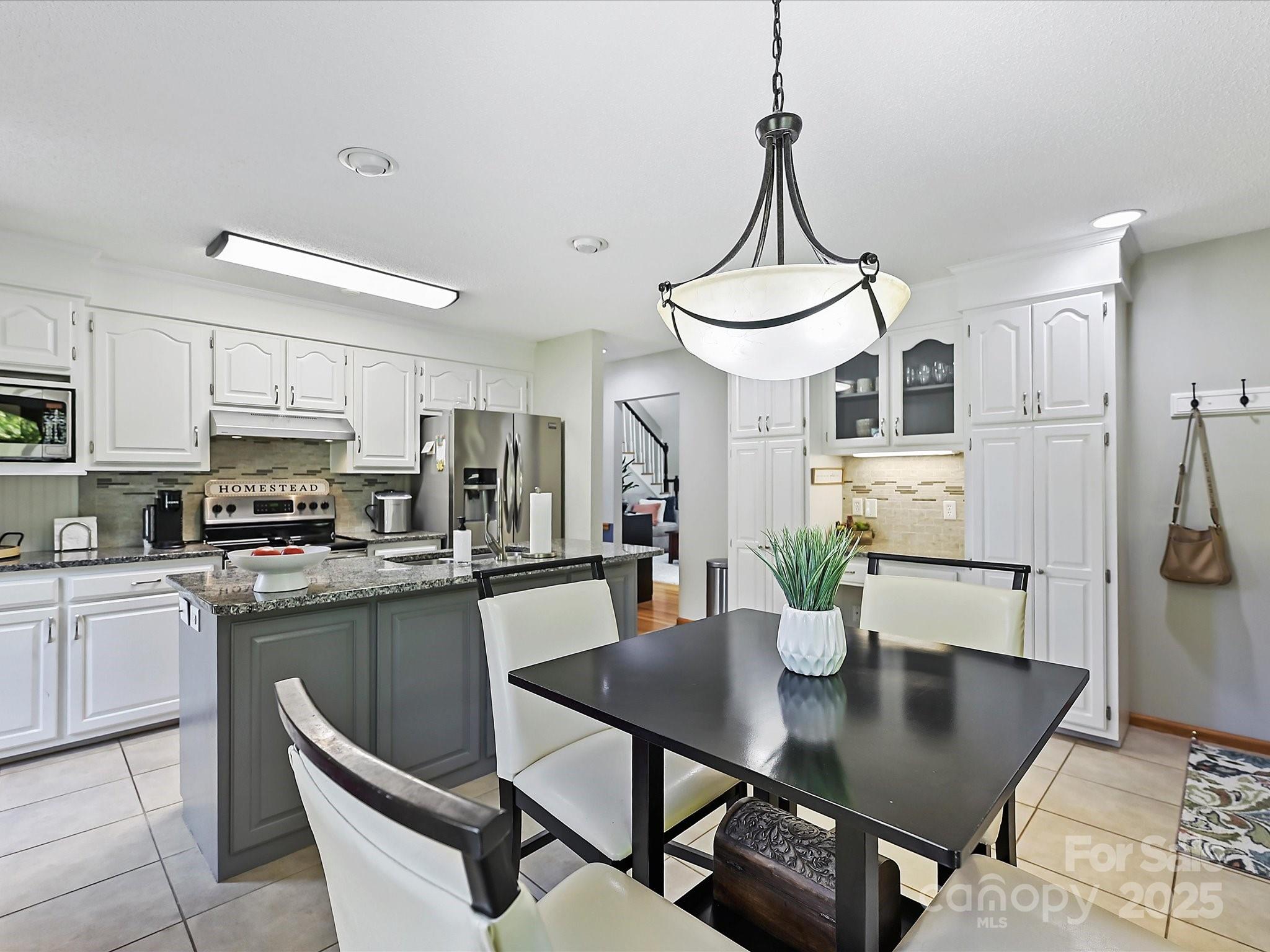 7146 Sifford Road Stanley, NC 28164 - Photo 15 of 42 a kitchen with stainless steel appliances kitchen island granite countertop a dining table chairs and a refrigerator