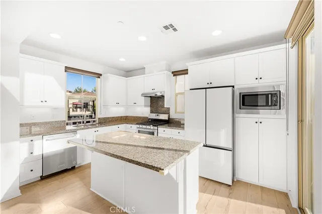 a kitchen with white cabinets and stainless steel appliances