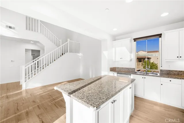 a kitchen with granite countertop a sink and a stove