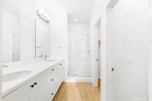 a bathroom with a double vanity sink a mirror and a bathtub