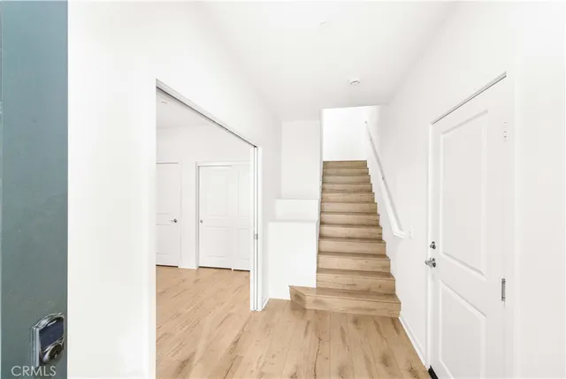 a view of a hallway with wooden floor and staircase
