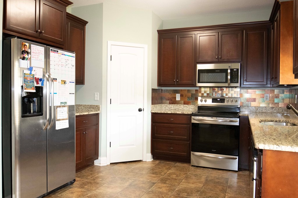 147 McLendon Road Fort Mitchell, AL 36856 - Photo 8 of 17 a kitchen with stainless steel appliances granite countertop a stove a refrigerator and a sink