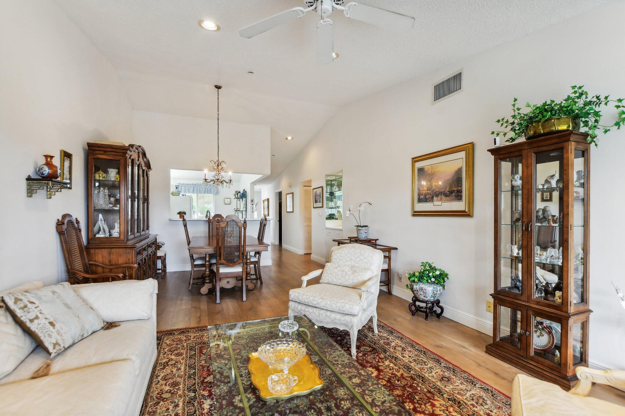 400 Northwest 67th Street, Unit 207 Boca Raton, FL 33487 - Photo 10 of 46 a living room with furniture a chandelier and a table