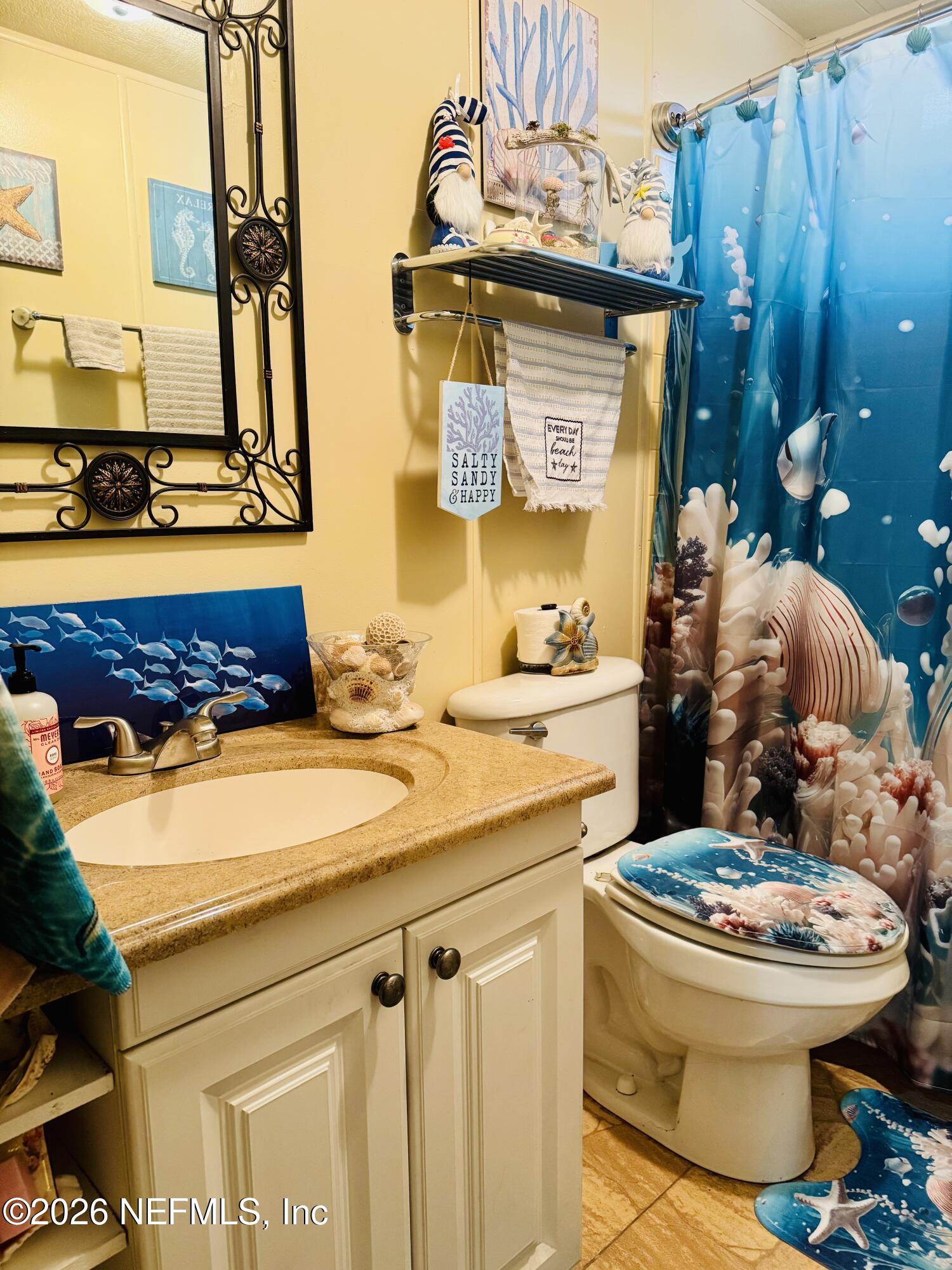 4700 Berry Court Keystone Heights, FL 32656 - Photo 39 of 65 a bathroom with a toilet sink and mirror
