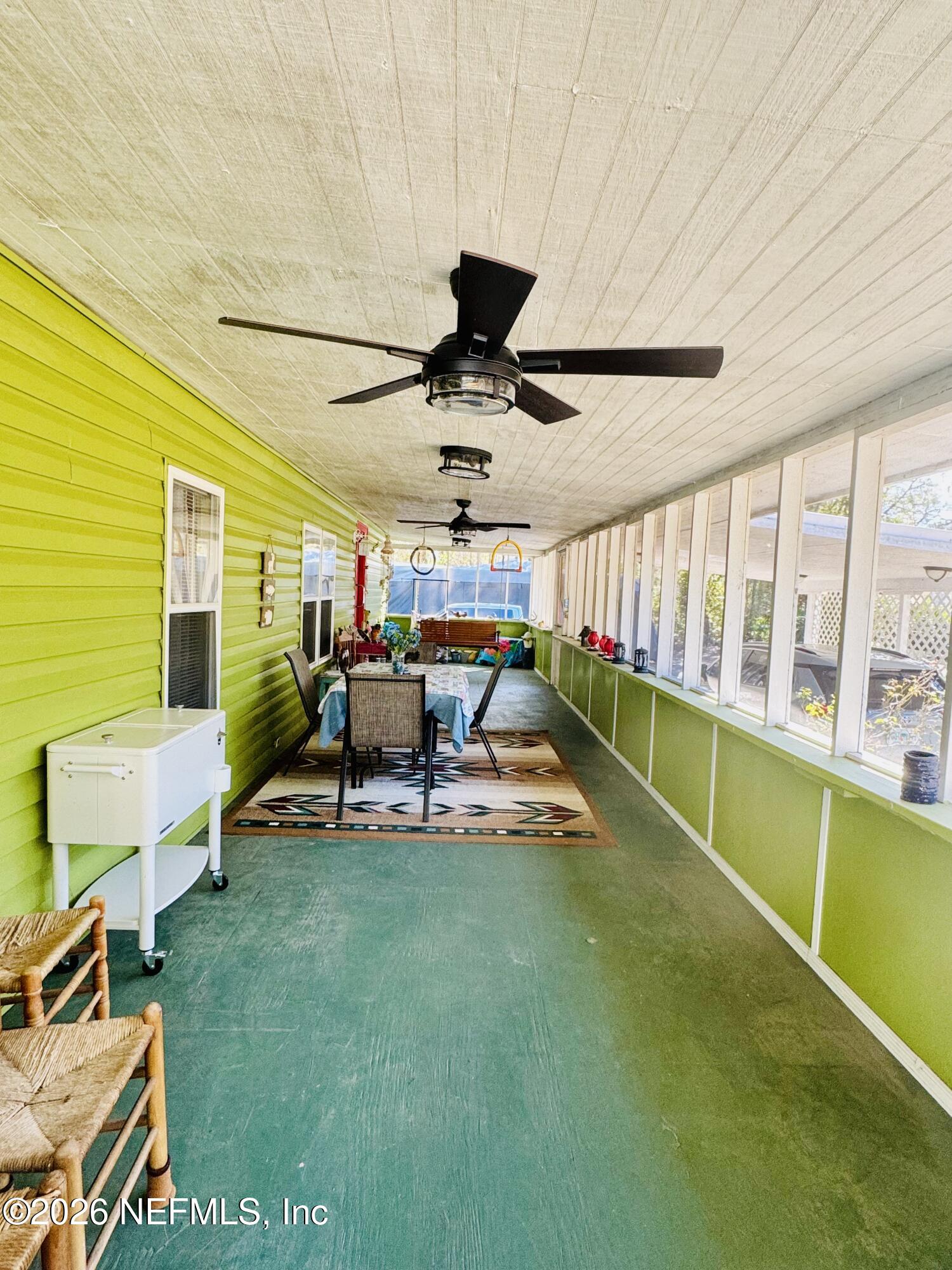 4700 Berry Court Keystone Heights, FL 32656 - Photo 45 of 65 a living room with furniture a flat screen tv and a floor to ceiling window
