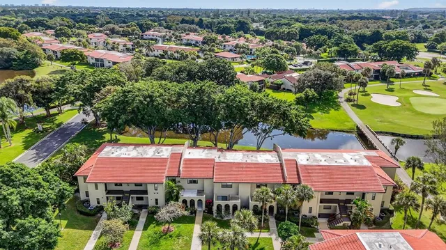 an aerial view of residential houses with outdoor space and trees