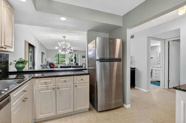 a kitchen with refrigerator and cabinets
