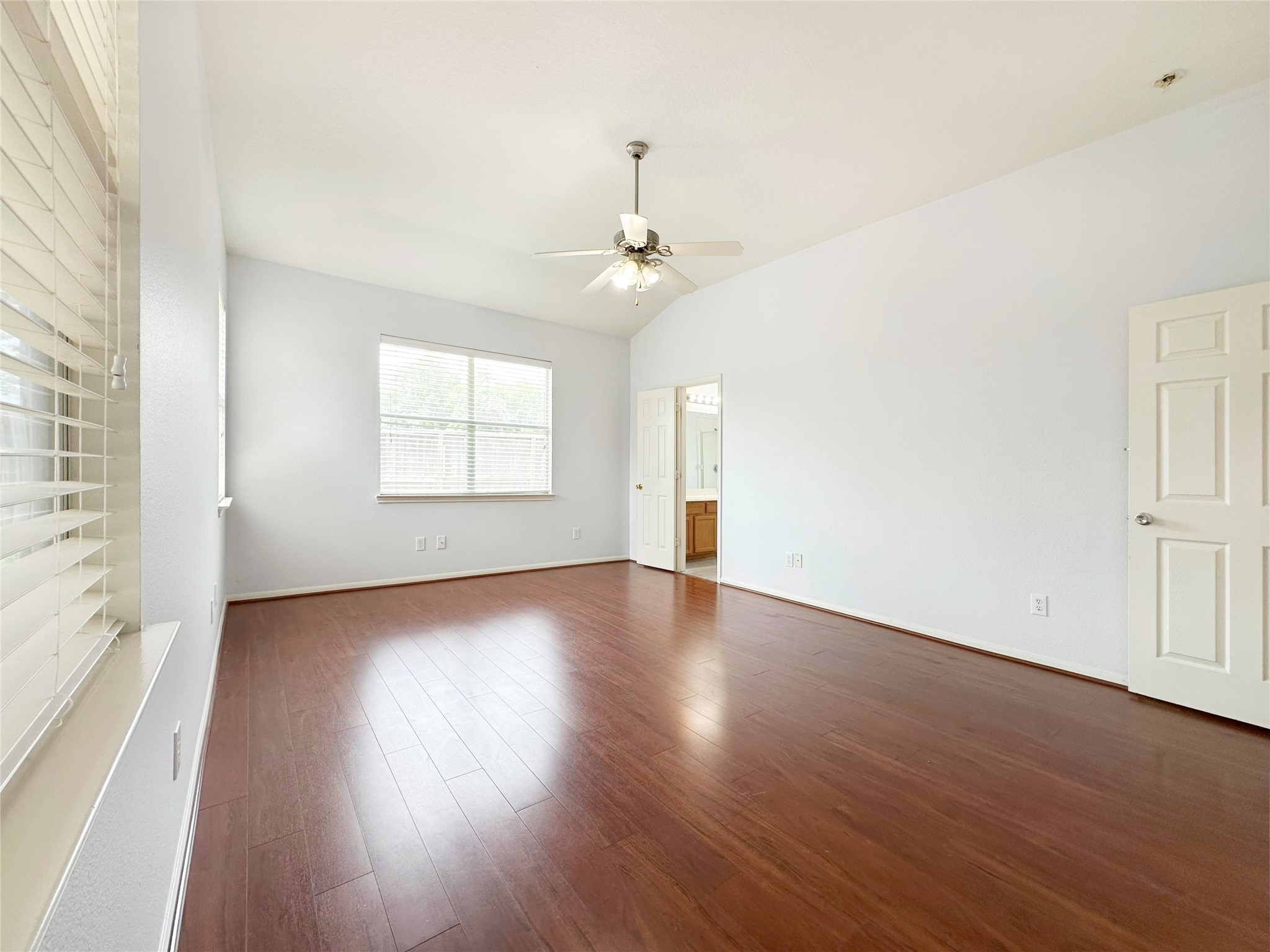 2910 Lemmingham Drive Spring, TX 77388 - Photo 24 of 31 an empty room with wooden floor chandelier fan and windows