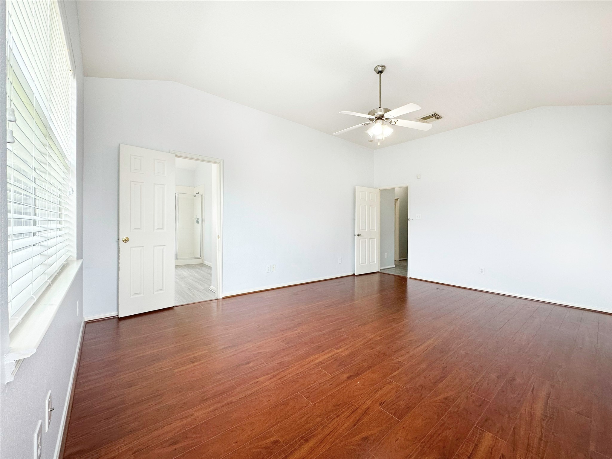 2910 Lemmingham Drive Spring, TX 77388 - Photo 25 of 31 an empty room with wooden floor ceiling fan and windows
