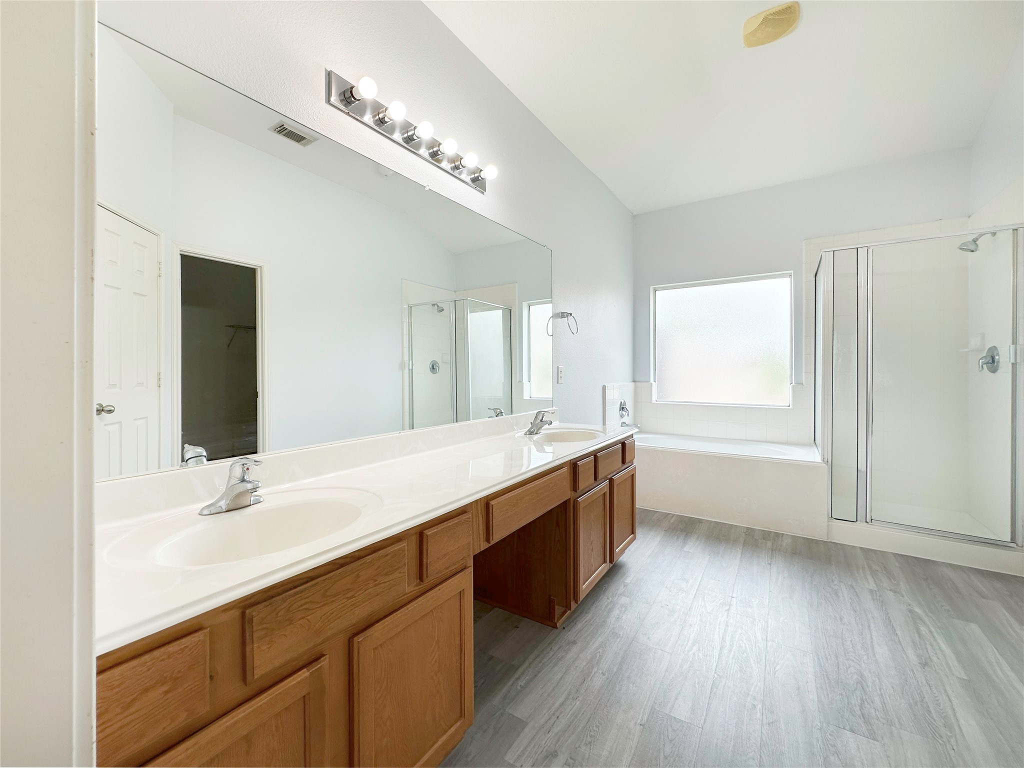 2910 Lemmingham Drive Spring, TX 77388 - Photo 26 of 31 a bathroom with a double vanity sink a mirror and a bathtub