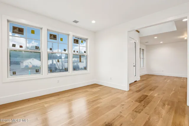 a view of a hallway with wooden floor and windows