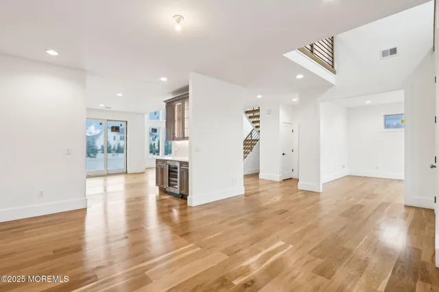 a view of empty room with wooden floor and windows