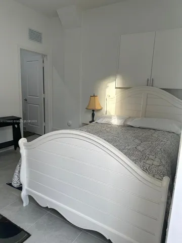 a bedroom with a bed and a lamp