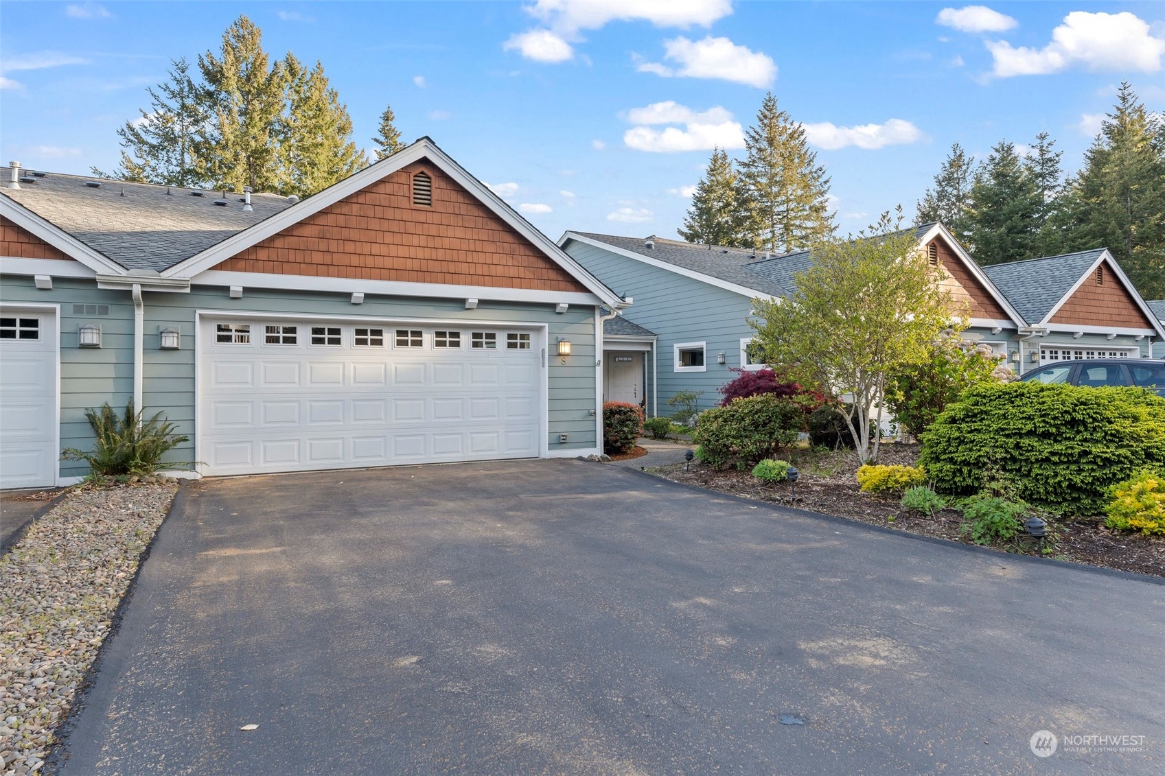 91 East Soderberg Road, Unit C8 Allyn, WA 98524 - Photo 2 of 39 a front view of a house with a yard and garage