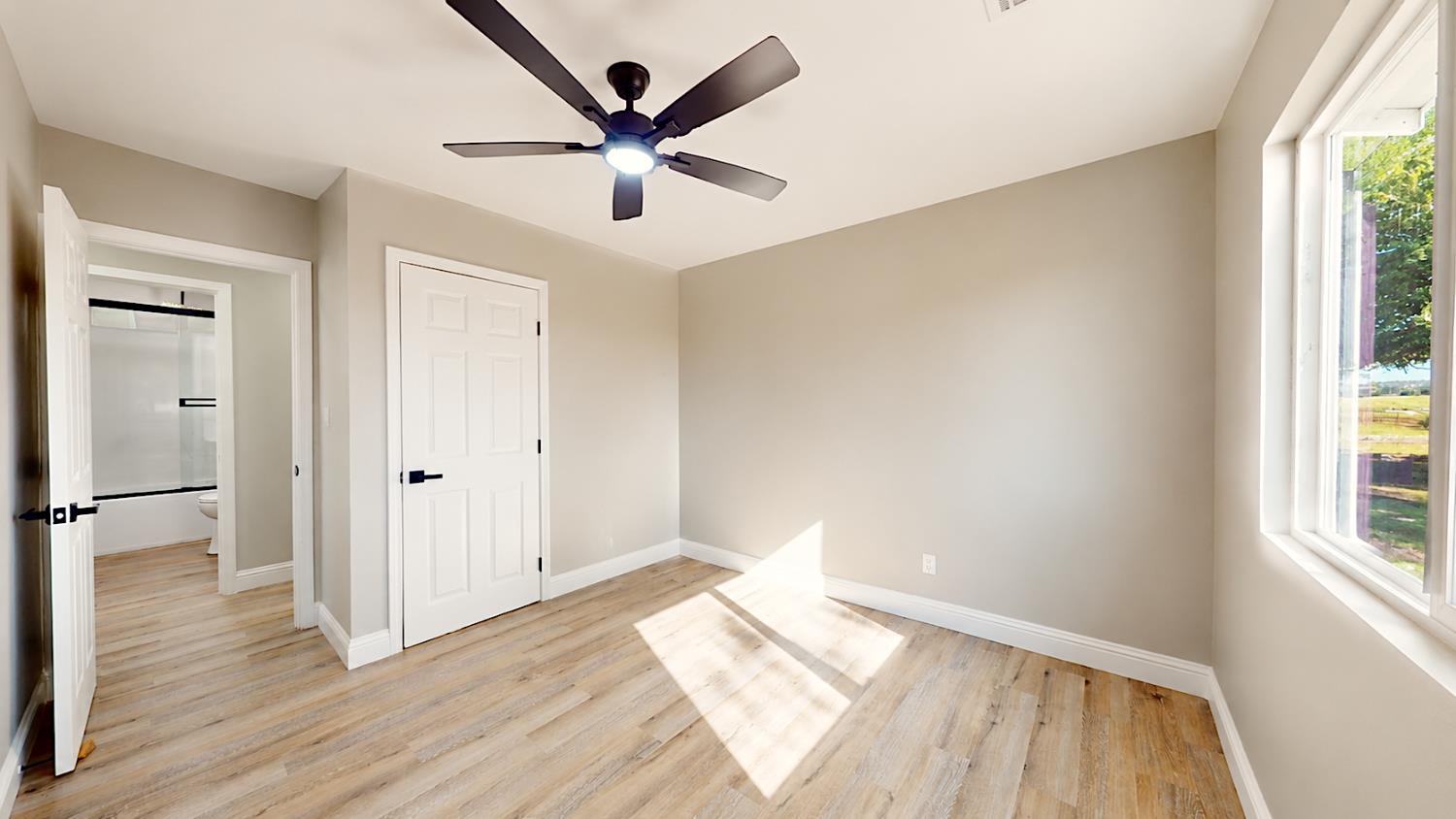 4728 Zorro Road La Grange, CA 95329 - Photo 32 of 56 Bedroom 2. Light wood-finish flooring, ceiling fan with integrated lighting, white interior doors, and a window with a white frame