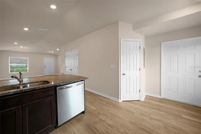 a kitchen with granite countertop a sink and a stove top oven with wooden floor