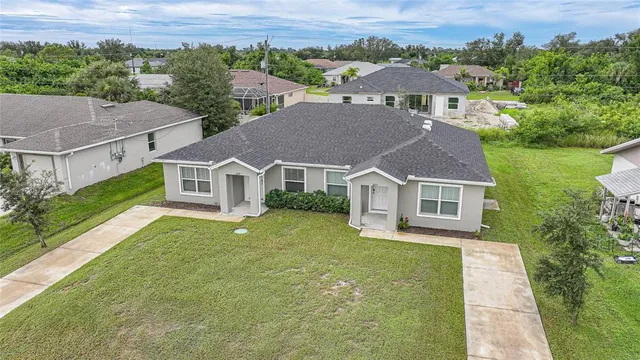 an aerial view of residential houses with outdoor space and trees
