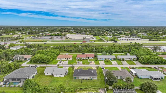 an aerial view of residential houses with outdoor space and trees