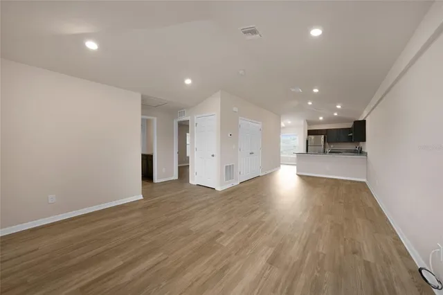 a view of empty room with wooden floor