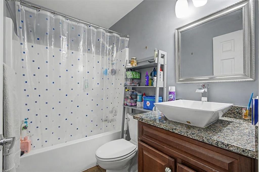 409 Windsor Way Canton, GA 30115 - Photo 21 of 51 a bathroom with a granite countertop sink a toilet a mirror a vanity and shower